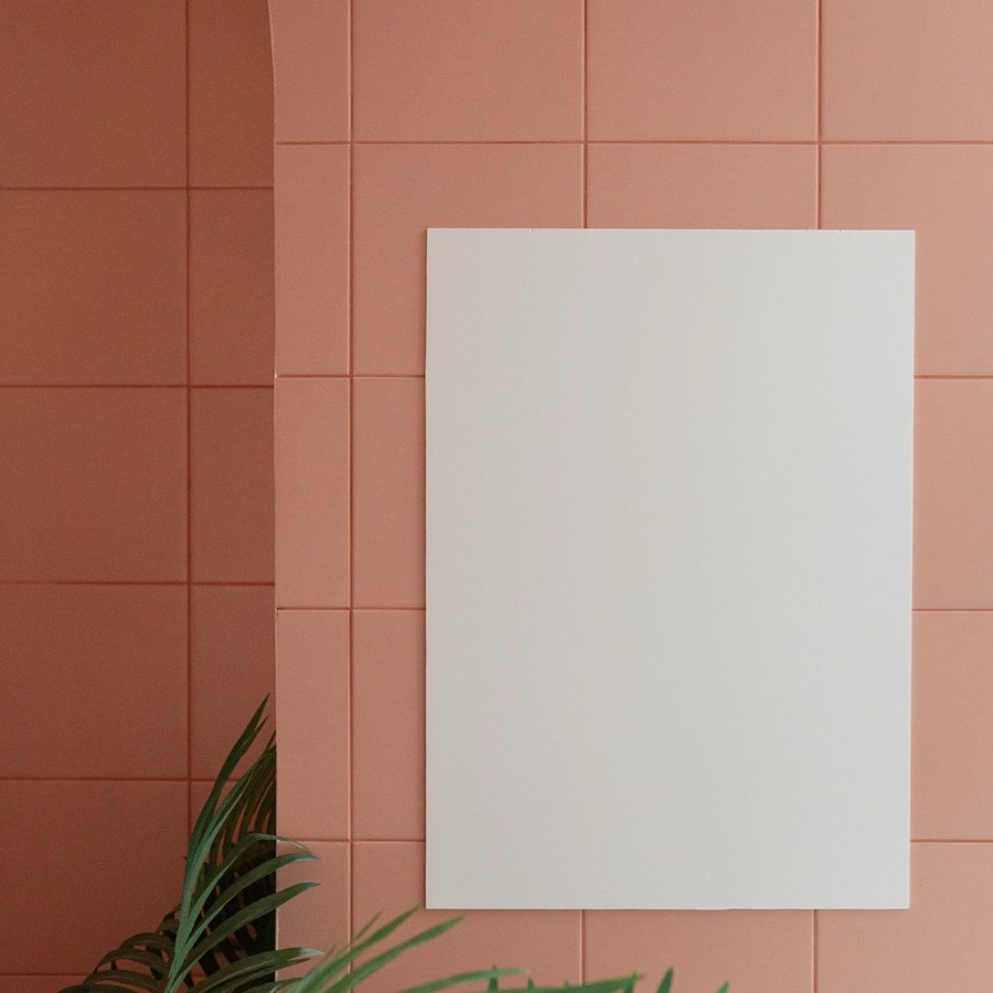 Personalisiertes Poster im Eichenrahmen an einer Terrakotta-Wand mit Palmblatt, Boho-Einrichtung
